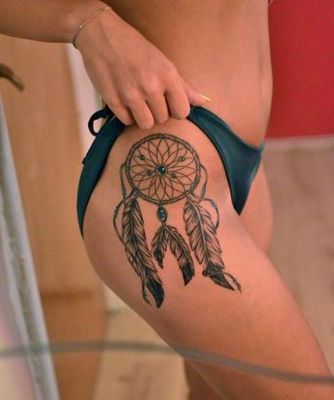  Tatouage attrape rêve noir, gris et bleu-clair sur femme vu de coté